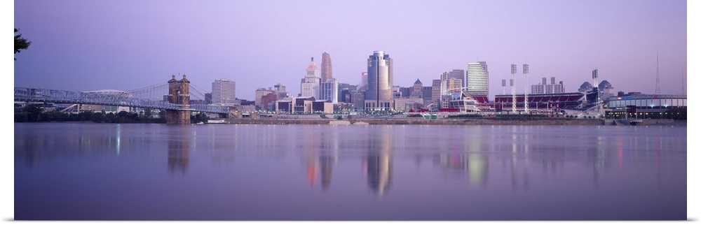A wide angle photograph is taken from across the river of the skyline in Cincinnati during the evening.