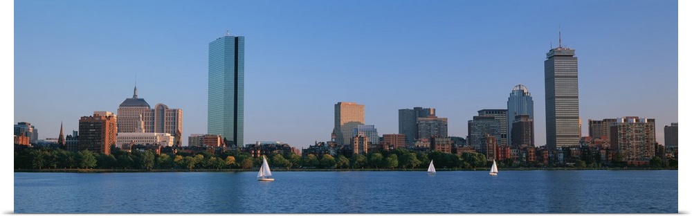 Panoramic photo on canvas of buildings lining a waterfront with three sail boats sailing.