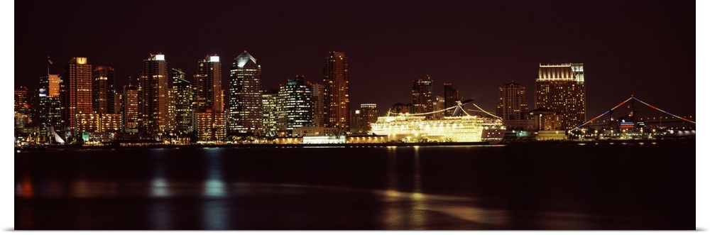Panoramic photograph on a big wall hanging of the San Diego skyline along the edge of the water, lit up at night.