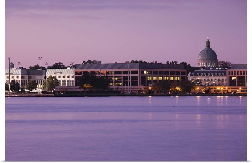 Wall art of the US Naval Academy building on the waterfront at dusk.
