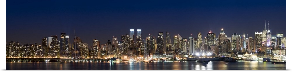 This wall art is a panoramic photograph of the marvelous city skyline illuminated at night.