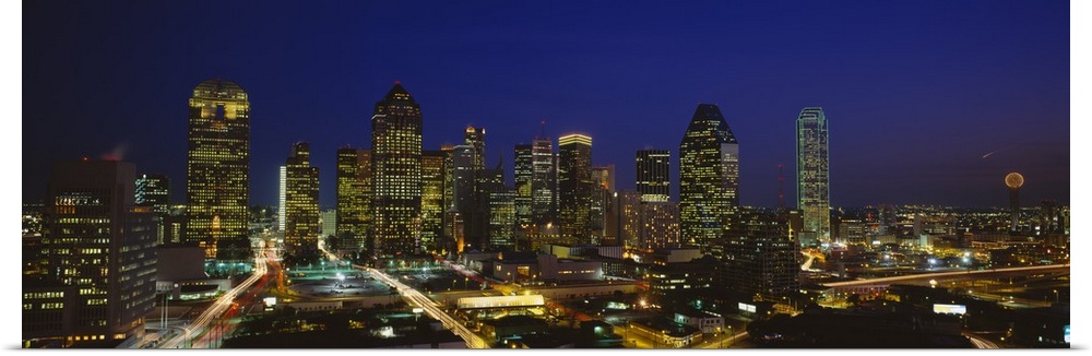 Panoramic photograph showcases the busy skyline of Dallas, Texas as it shines at night.