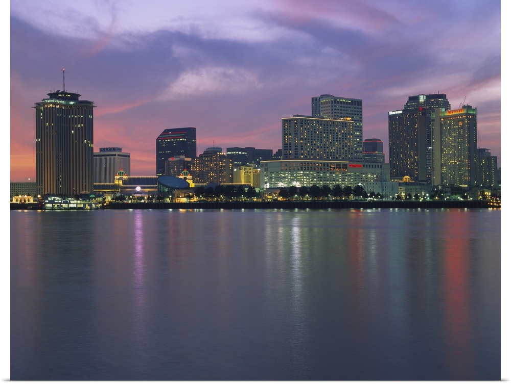 Panoramic photograph of skyline at waterfront.  The building lights are reflected in the water below.