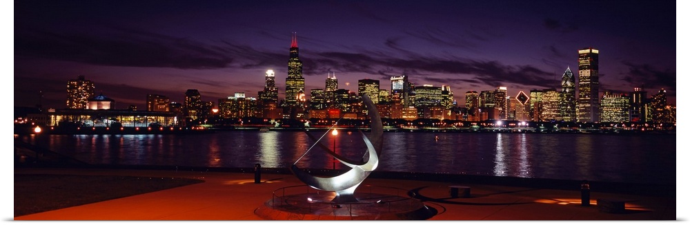 Panoramic photograph of skyline and waterfront at night.