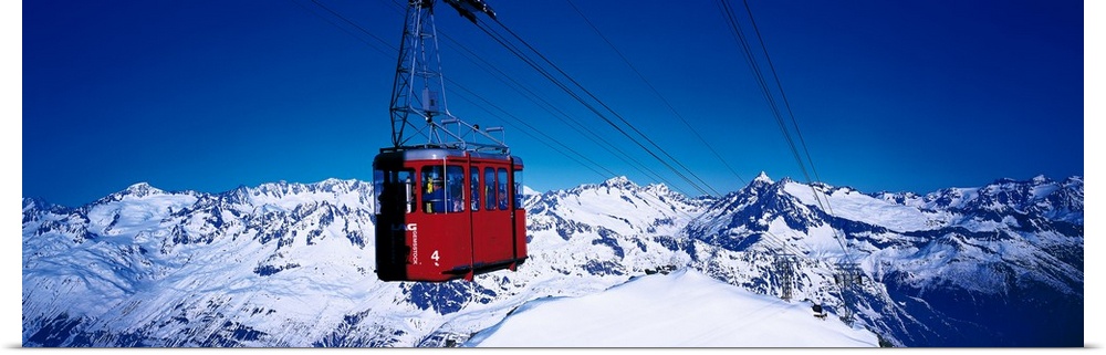 An aerial tramway overlooking the snowcapped mountains in Andermatt, Switzerland.
