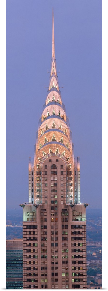 Lit up spire and top floors of the Chrysler building at dusk.