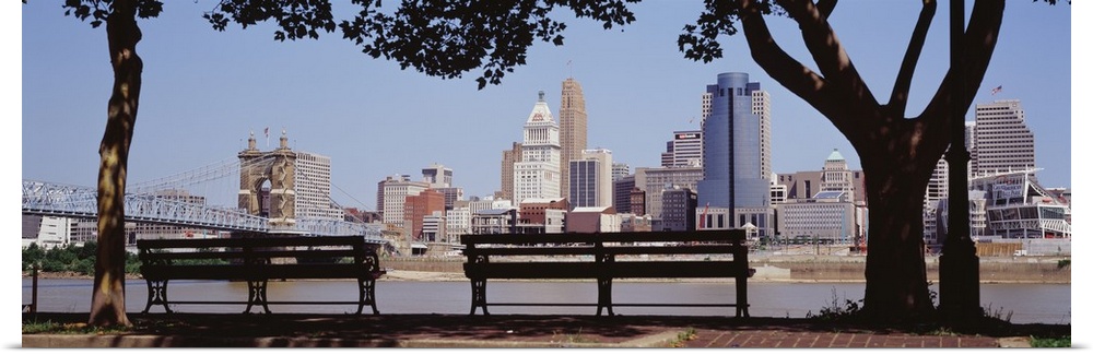 Giant, wide angle photograph of two park benches looking toward the Cincinnati skyline in Ohio.