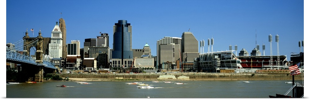 Boats skimming along the Ohio River with downtown Cincinnati in the background.