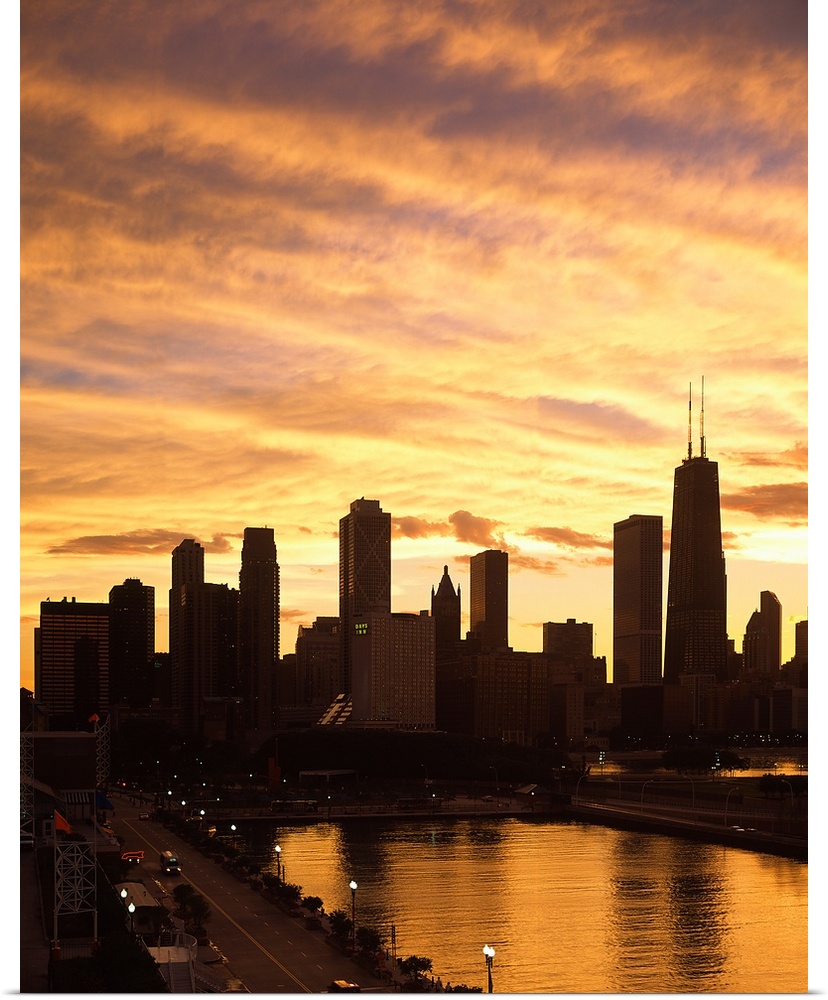 Giant, vertical photograph of the Chicago skyline and Navy Pier beneath a golden sky of wispy clouds at sunset.