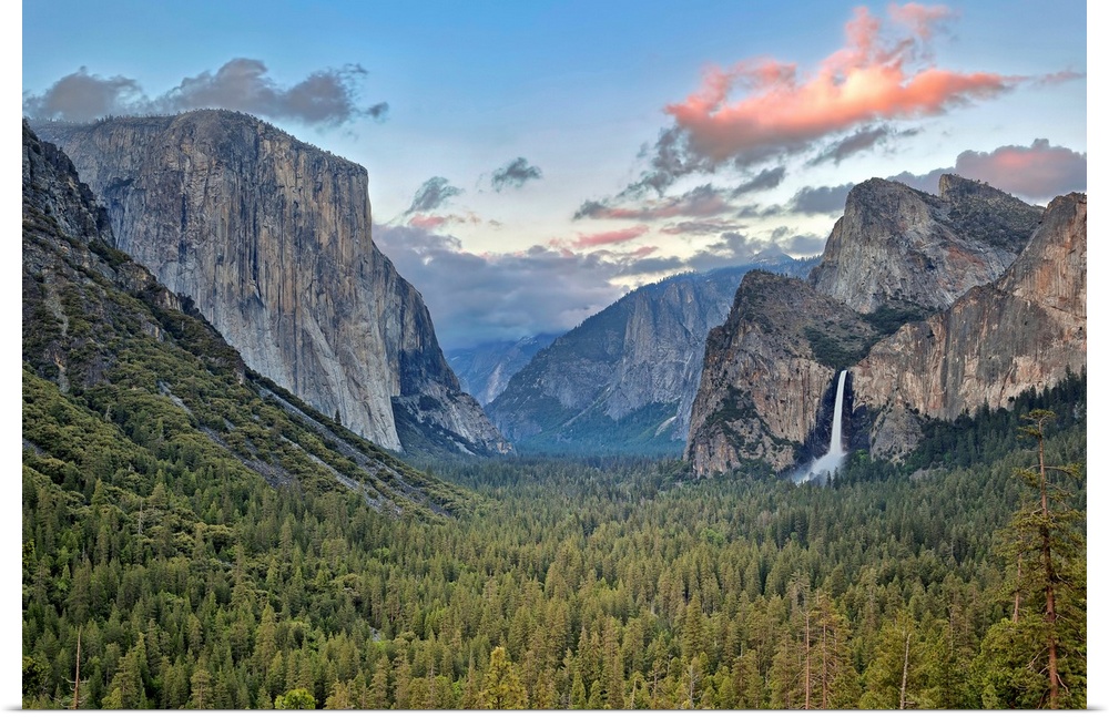 Landscape photograph on a big canvas of Yosemite Valley, green tree tops surrounded by mountains, a large waterfall can be...