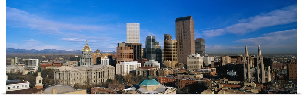Panoramic photo of a downtown cityscape in Colorado against a bright blue sky.