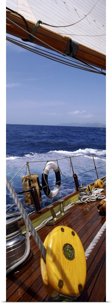 This photograph is taken on a sailboat showing the detail of the deck on the boat and side railing.