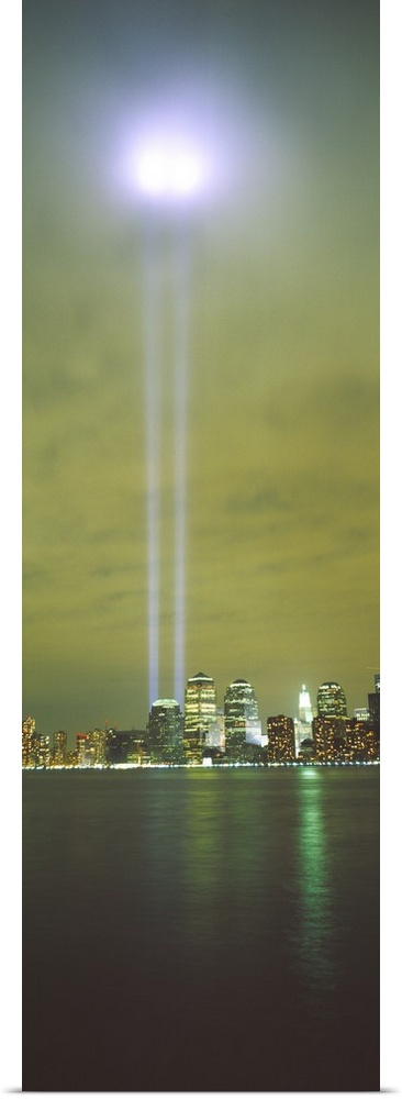 Vertical panoramic piece of a photograph of the lights shining up from where the twin towers stood.