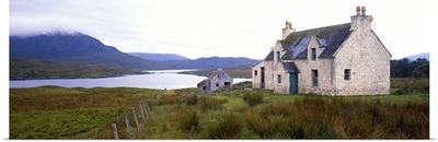 Farm house on bluff, mountains in mist, Isle of Lewis, Scotland