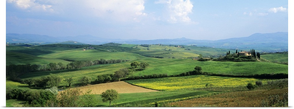 Vast land and large green fields in Italy are pictured in a wide angle view.