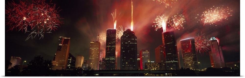 Fireworks explode in the night sky behind the backdrop of the Houston downtown skyline.