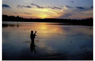Fly-fisherman silhouetted by sunrise, Mauthe Lake, Kettle Moraine State Forest, Wisconsin