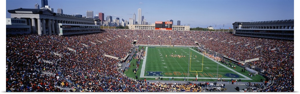 Panoramic photograph of NFL stadium with the city's skyline in  the distance under clear skies.  The arena is filled with ...