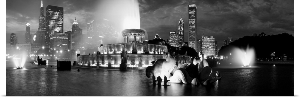 A panoramic photograph of the Chicago Skyline highlighting a large fountain in black and white.
