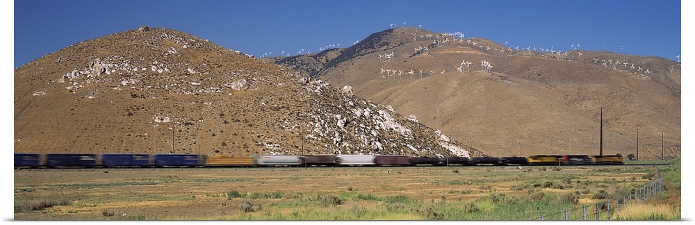 Speeding train and mountains. Speeding train at base of mountains with wind turbines in Tehachapi, CA.