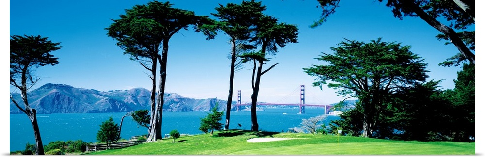 Big panoramic photograph of a seaside golf course in San Francisco, California (CA) with mountains and the Golden Gate Bri...