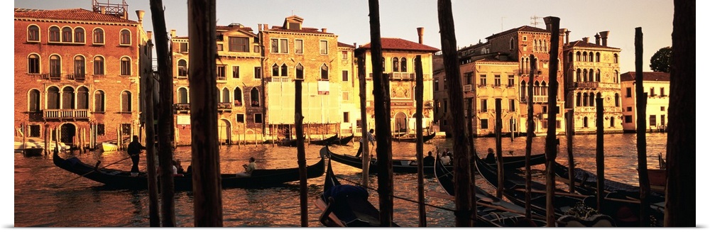 Panoramic photo of buildings along the canal in Venice, Italy at sunset.