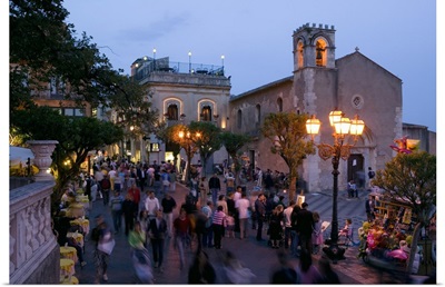 Group of people on the street at dusk, Piazza IX Aprile, Taormina, Sicily, Italy