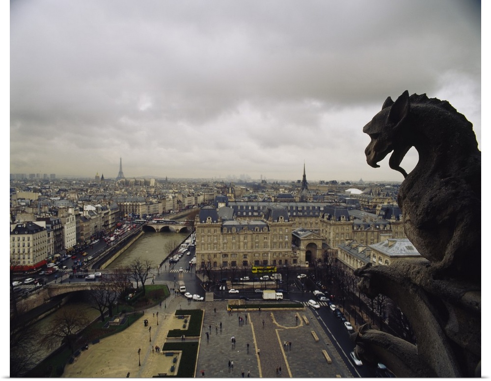 Horizontal, high angle photograph on a big canvas, looking past a gargoyle from the top of Notre Dame Cathedral, over the ...