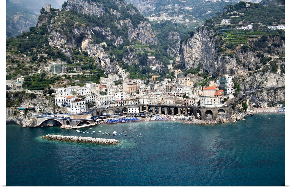 This decorative wall art is an aerial photograph of an Italian village and harbor build into steep costal hills.