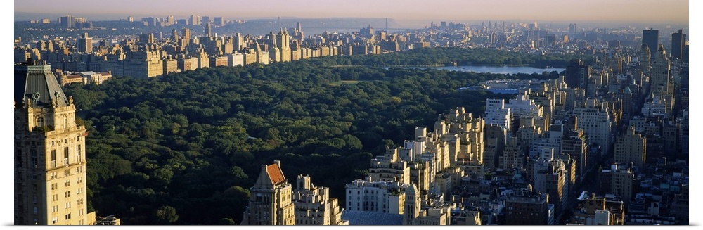 Panoramic canvas photo of the trees and lake in Central Park surrounded by the buildings of the city.
