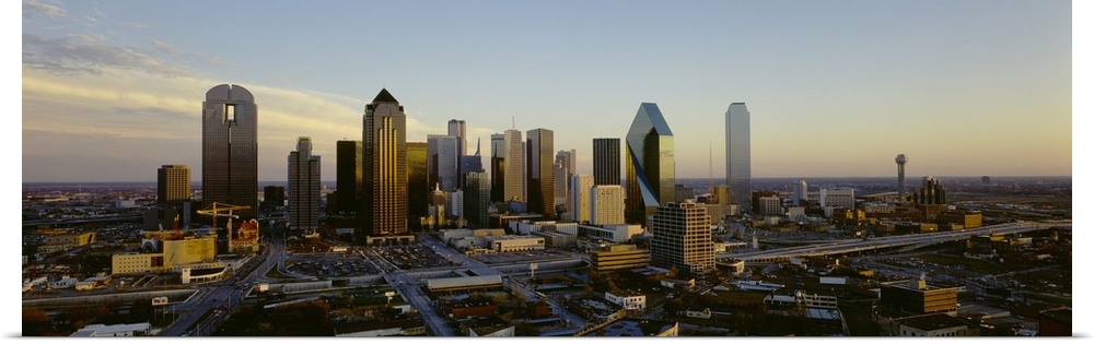 Buildings in the Dallas skyline are photographed in panoramic view during dawn.