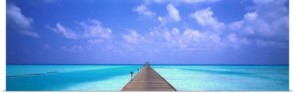 Giant panoramic photo of a wooden pier stretching into the horizon in Holiday Island in the Maldives. The wooden pier is s...