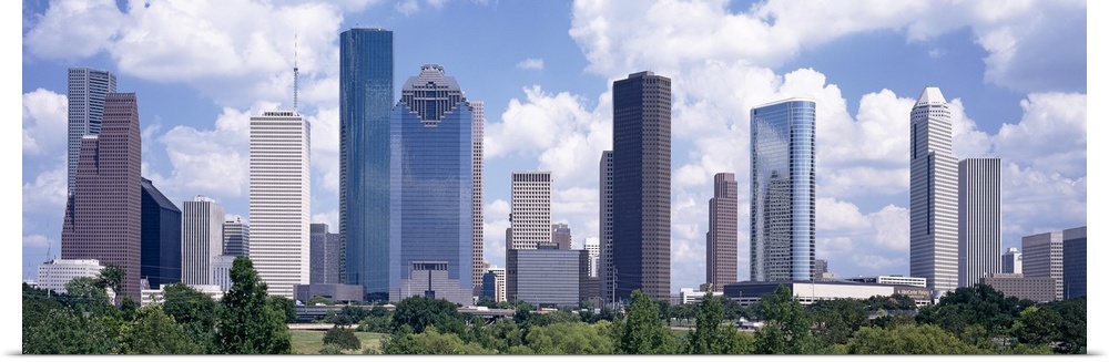 Giant, landscape wall picture of the Houston skyline, under a bright blue sky with many fluffy clouds.