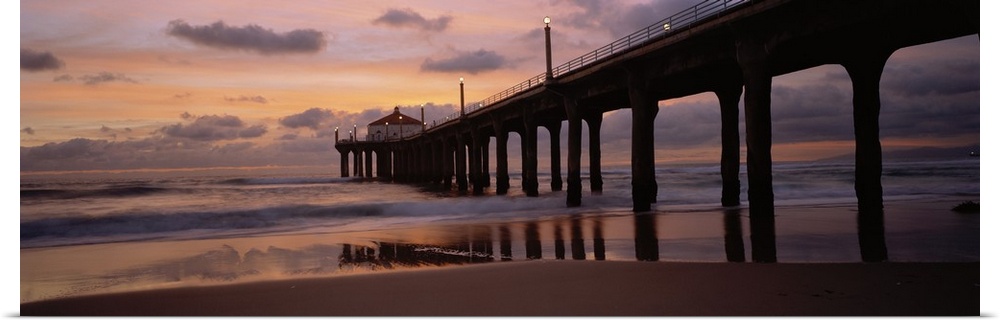 Wide angle photograph of Manhattan Beach Pier extending into the water at sunset, in Los Angeles County, California.