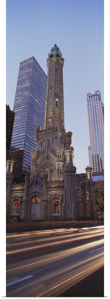 Vertical panoramic photograph of skyscrapers and tall buildings along city street.