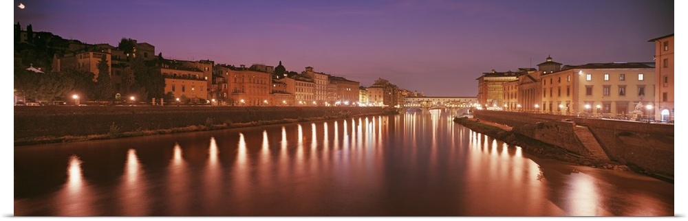 Italy, Florence, Arno River, Panoramic view of building along a lit up river