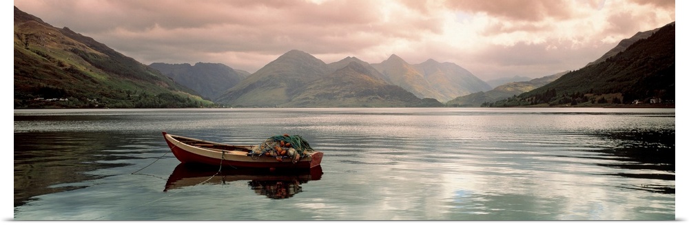 Panoramic photograph shows a small fishing vessel sitting anchored within a calm body of water north of the United Kingdom...