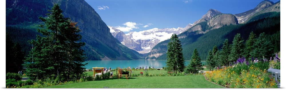 Panoramic wall docor of a smooth lakefront surrounded by rolling hills and snow capped mountains in the background.