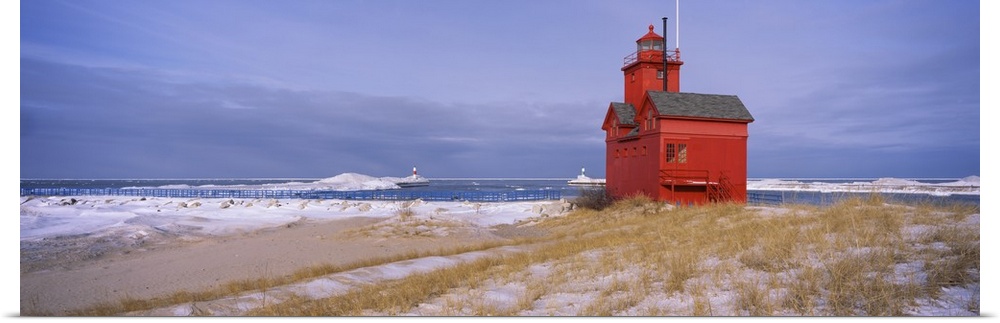 Big horizontal photograph of the Big Red Lighthouse against a blue sky, along the coast of Lake Michigan, in Holland, Mich...