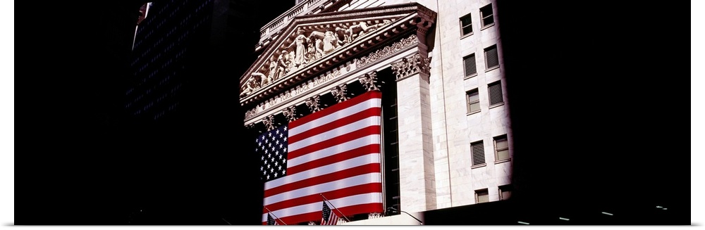 Low angle view of an American flag on a financial building, New York Stock Exchange, Wall Street, Manhattan, New York City...