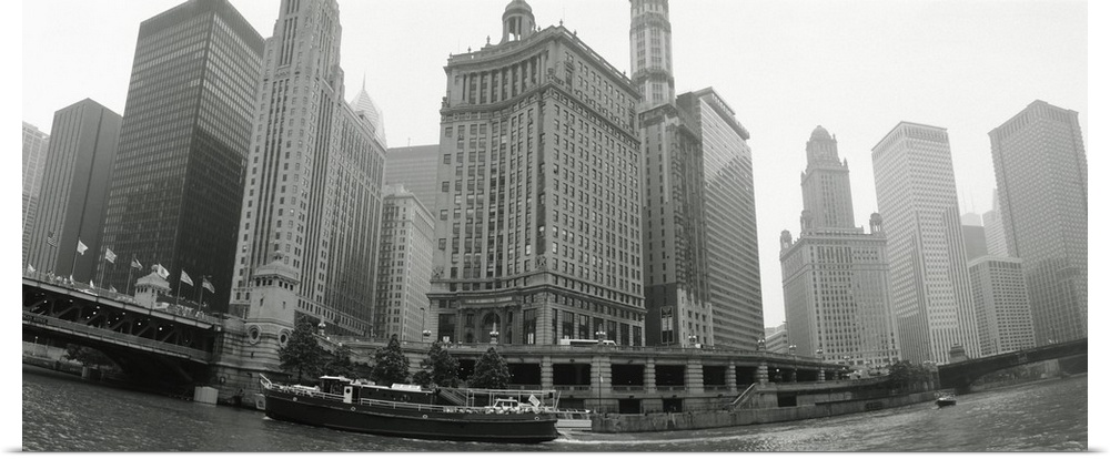 Large, horizontal photograph of boats and skyscrapers, taken at a low angle from the waterfront of Chicago, Illinois.