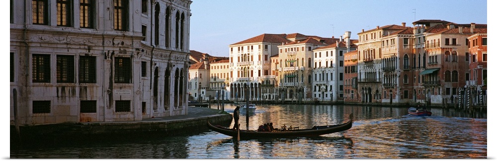 Man on a gondola in a canal, Grand Canal, Venice, Italy