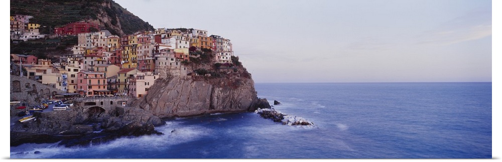 Panoramic photograph of colorful city on cliffs overlooking ocean.