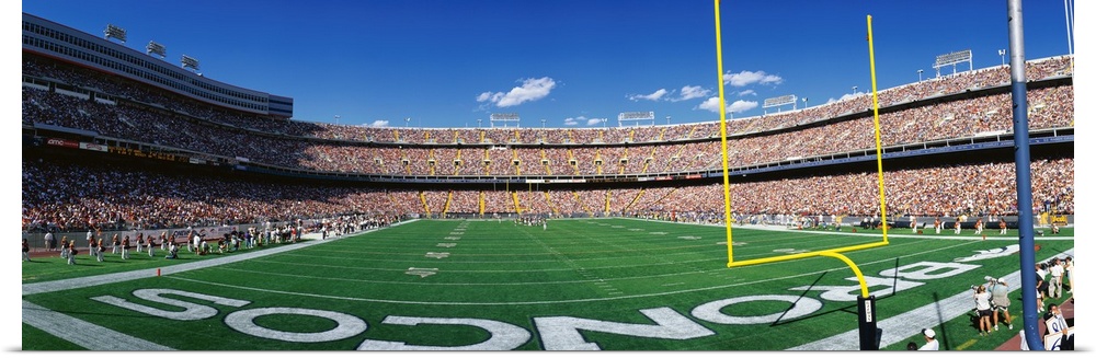 This is a wide angle shot of the broncos stadium taken from behind the end zone during a day game.