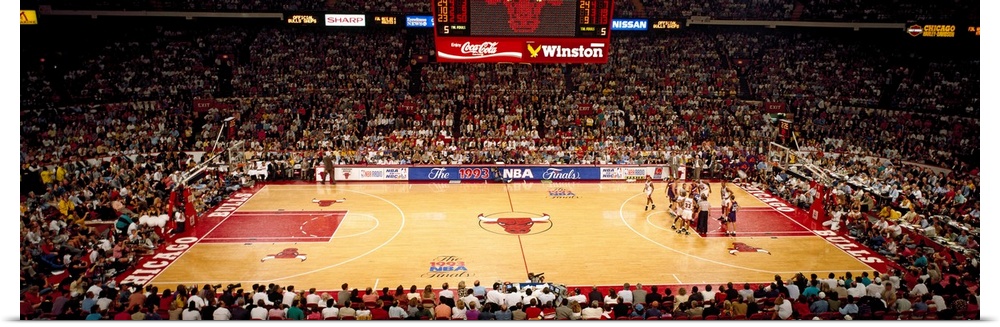 This is a panoramic photograph of an arena and basketball game.