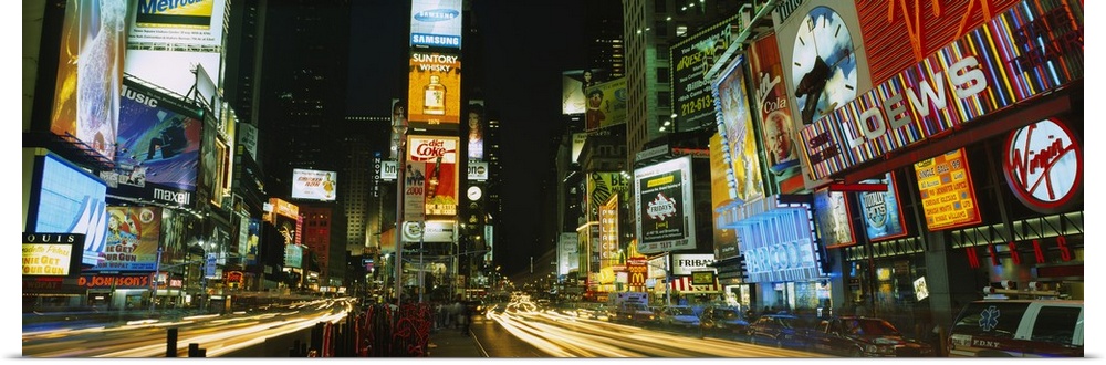 Wide angle photograph of Times Square in New York City, brightly lit at night.