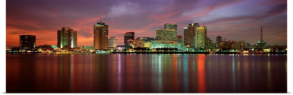 Panoramic photograph of the Crescent City skyline at twilight reflecting in the water.