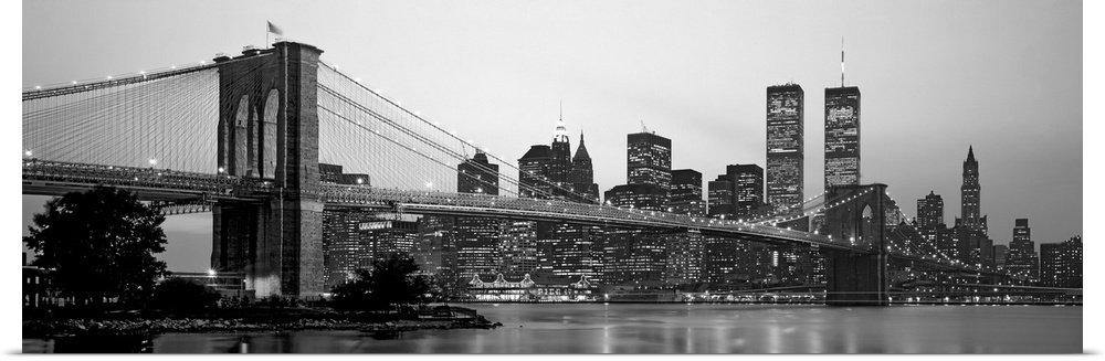 Panoramic photograph of the Brooklyn Bridge against a skyline filled with skyscrapers in New York.  The buildings and brid...
