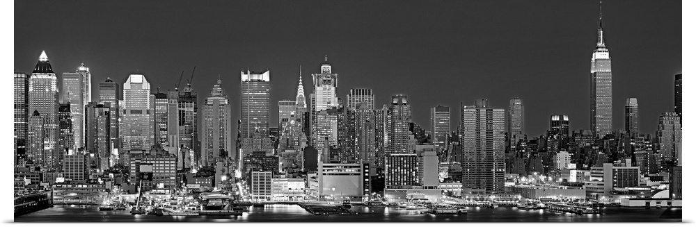The dense Manhattan skyline, as view from west of the city, is outlined and illuminated by lights in the night.