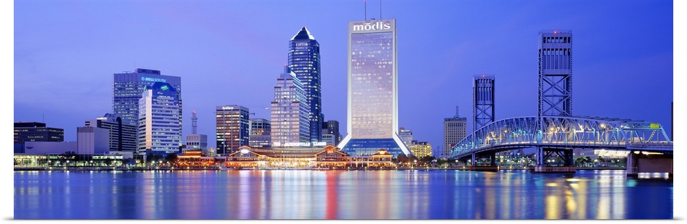 This large panoramic photograph is of the Jacksonville skyline with it's buildings lit up at night and reflecting in the w...